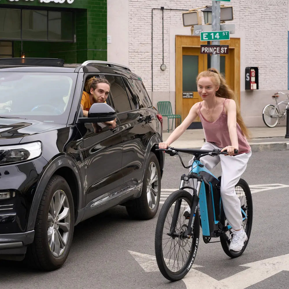Woman rides Starry Sky eBike on city street, passing a car