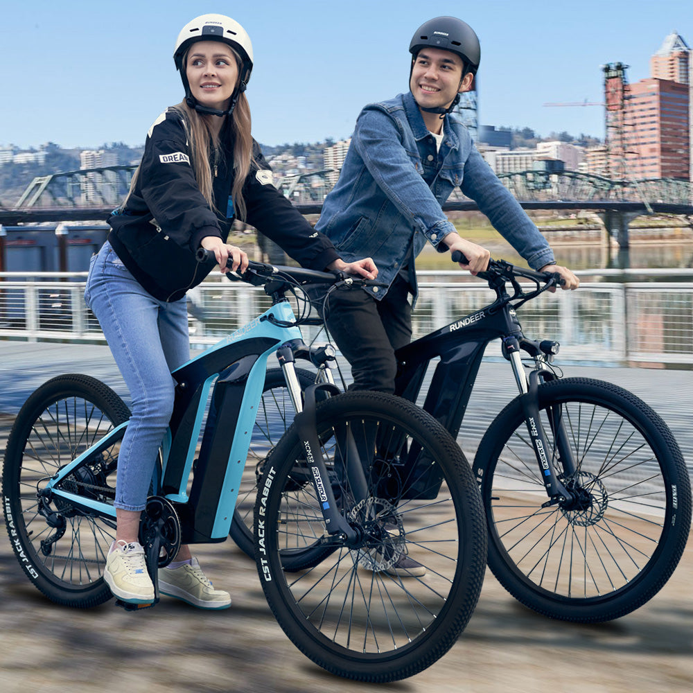 Couple riding Rundeer Starry Sky e-bikes in urban setting
